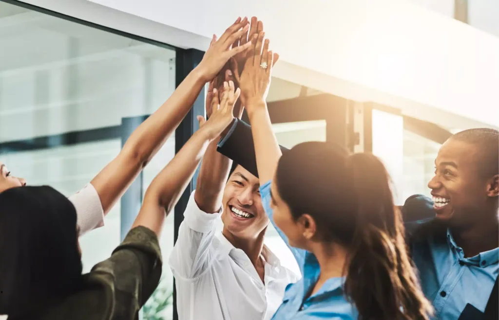 equipo de trabajo chocando las cinco celebrando