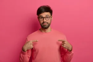 hombre sorprendido apuntándose a si mismo por su ego