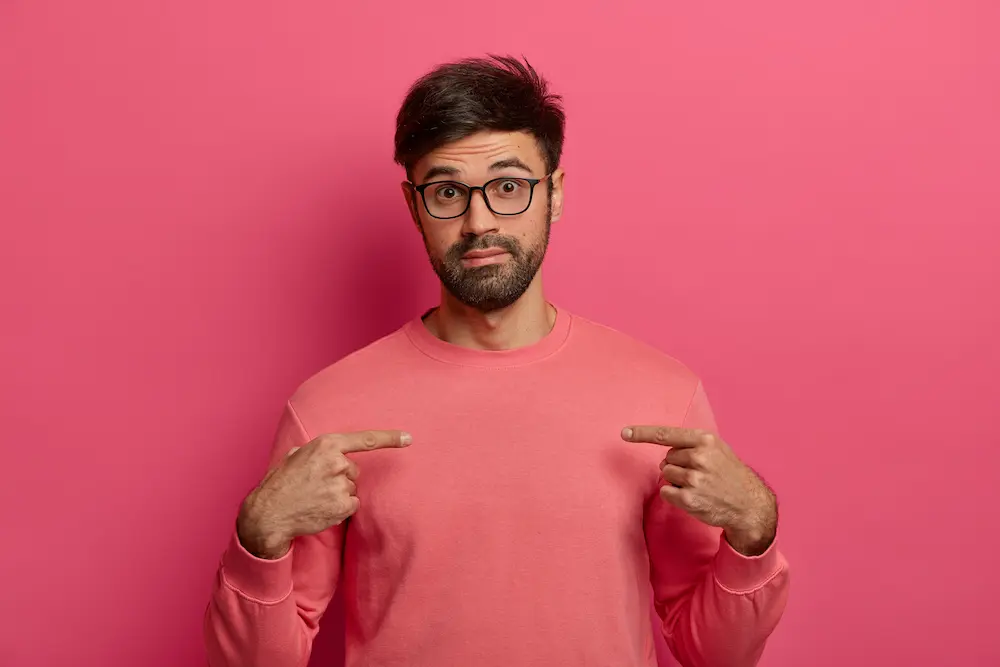 hombre sorprendido apuntándose a si mismo por su ego