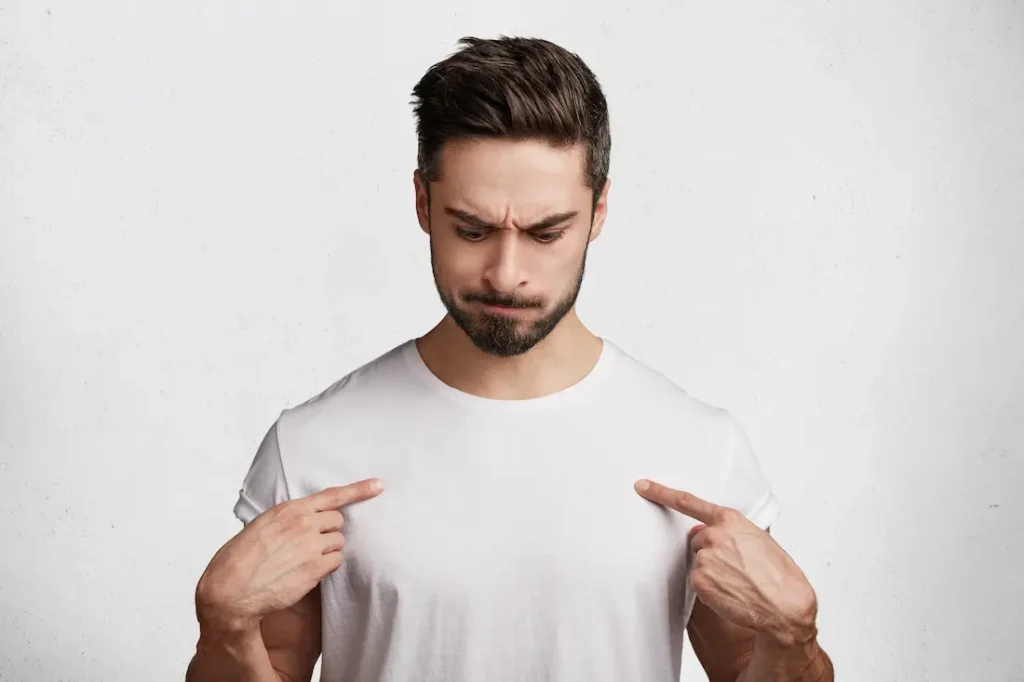 hombre apuntandose con ambas manos